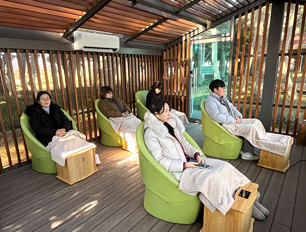 나무로 지어진 건물에 편안한 의자들이 일렬로 배치되어 있는 모습