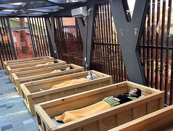 나무로 만들어진 베드안에 맥반석 온열 기기가 설치되어 있는 허브 맥반석 치유관 모습